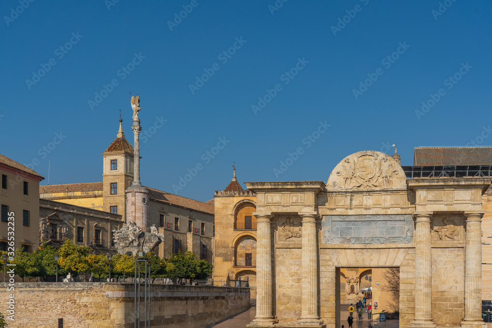View of the monument Puerta del Puente, Cordoba, Andalusia, Spain. Isolated on blue background.