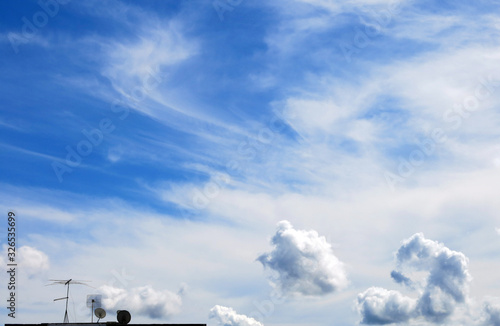 Small tv antennas and blue sky background with clouds
 photo