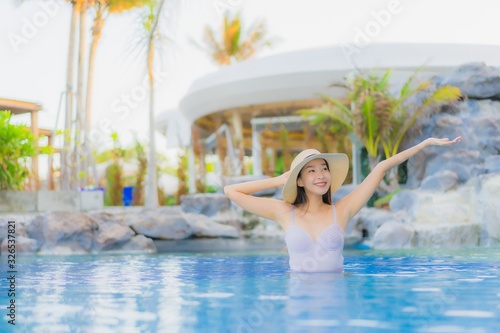 Portrait beautiful young asian woman happy smile relax around outdoor swimming pool in hotel resort