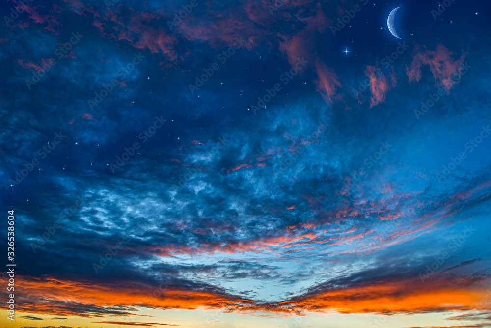 Fototapeta premium Moon in bright clouds of sunset sun . New moon