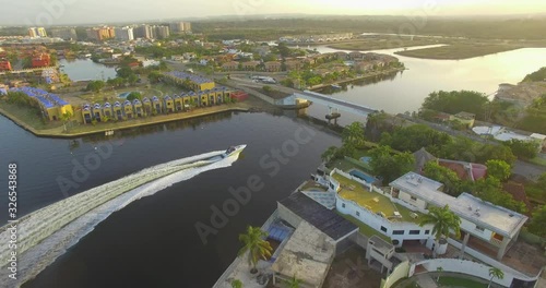 Aerial view of a fast boat in the Higuerote canals , in Venezuela, sailing under the bridge in the golden hour photo