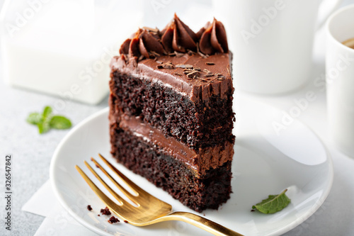 Dark chocolate cake slice with chocolate buttercream frosting photo