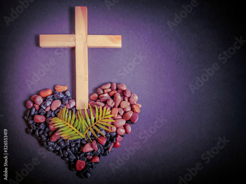 Lent Season,Holy Week and Good Friday concepts - photo of wooden cross with palm leaves and stones in purple vintage background photo