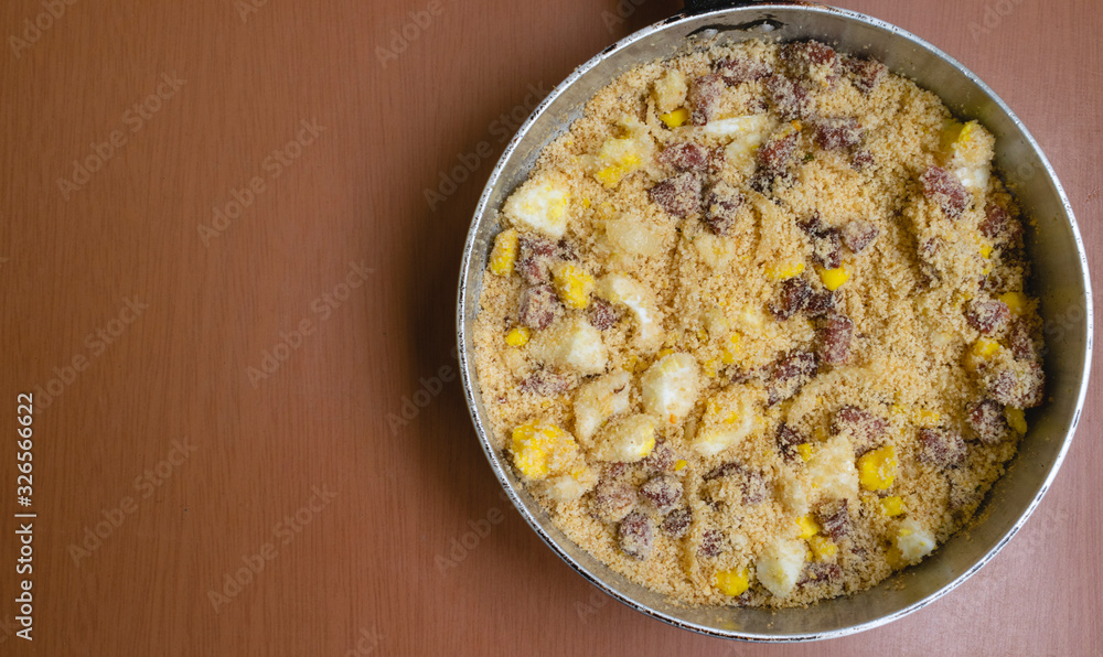 bacon farofa in the pan on the wooden table bacon farofa in the pan on the wooden table