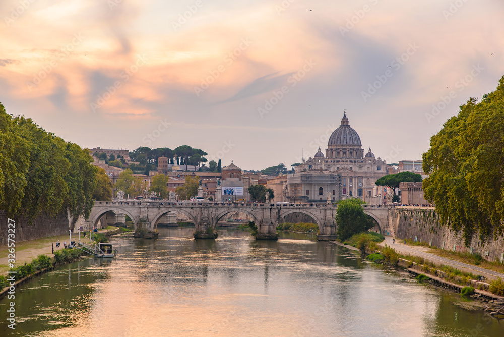 Sunset view of St. Peter's Basilica, Ponte Sant'Angelo, and Tiber River in Rome, Italy