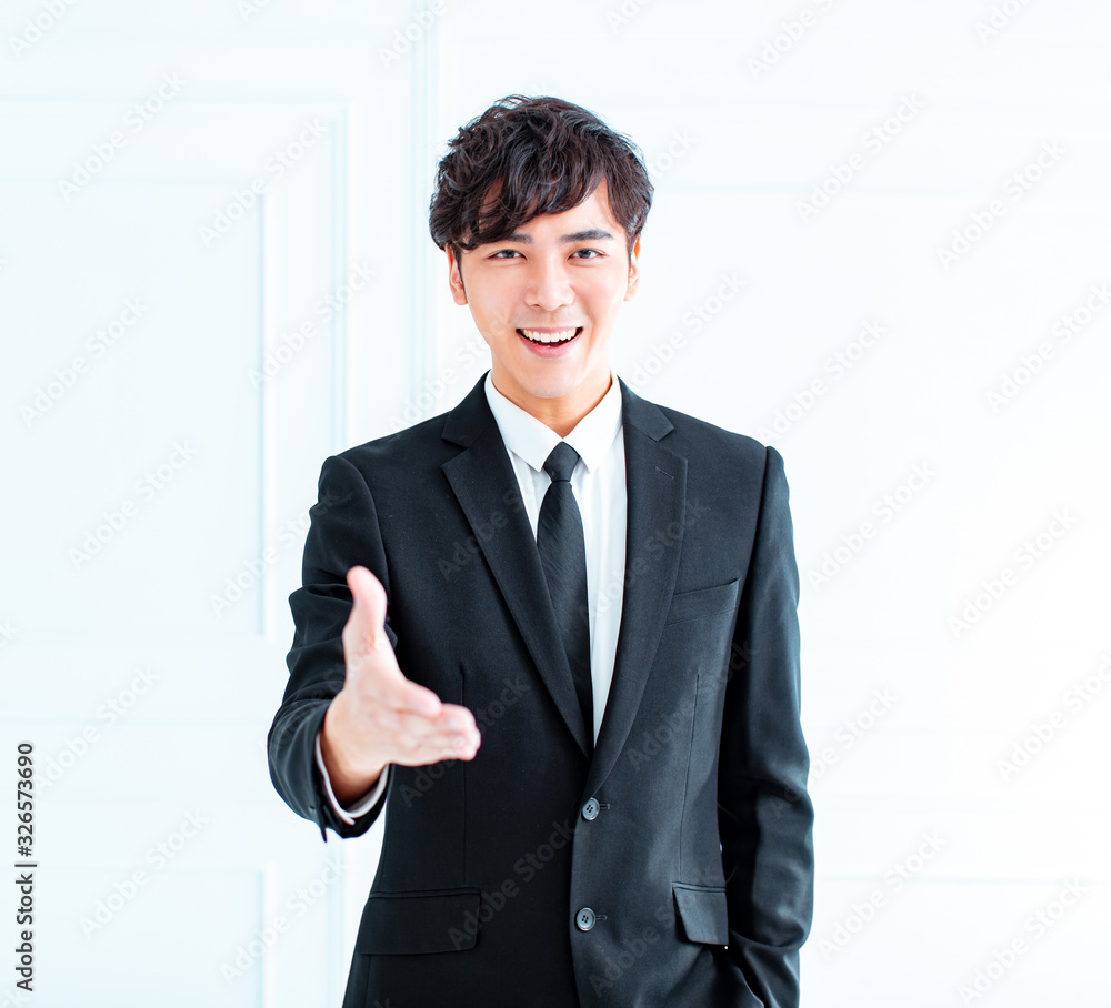 smiling businessman reaching out for a handshake smiling businessman reaching out for a handshake