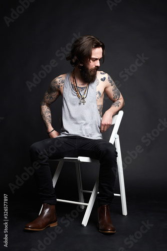 Tattooed handsome Man sitting on a chair