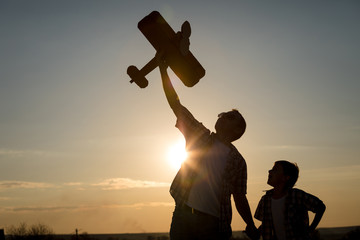 Father and son playing with cardboard toy airplane