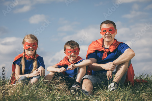 Father and children playing superhero at the day time.