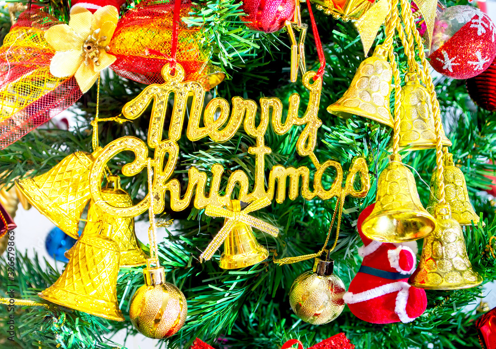 Naklejka premium gold merry chirstmas word and Ornaments on christmas tree isolate on white background