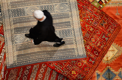 Εκτύπωση καμβά Morrocan Riad owner shopping for a new persian rug in Fes el Bali Medina Morocco