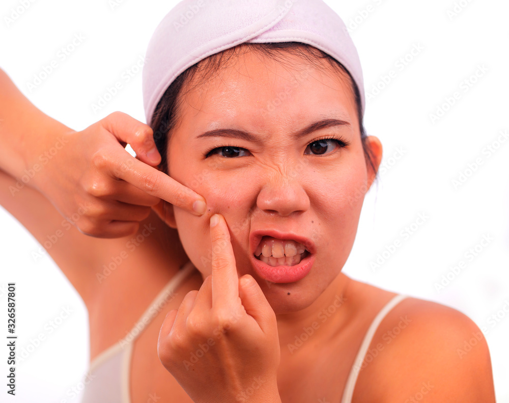 young beautiful angry and upset Asian Korean woman with acne pooping head of pimple with her fingers on the mirror cleansing the skin in beauty treatment concept isolated on white young beautiful angry and upset Asian Korean woman with acne pooping head of pimple with her fingers on the mirror cleansing the skin in beauty treatment concept isolated on white