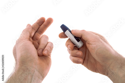 The lancing device is directed to the tip of the finger for analysis for diabetes. Isolated on a white background