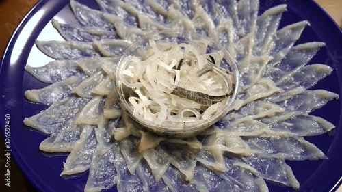 JAPANESE FOOD: Delicious fresh fugu sashimi (Puffer Fish) on dish, top view. Shot in 4K