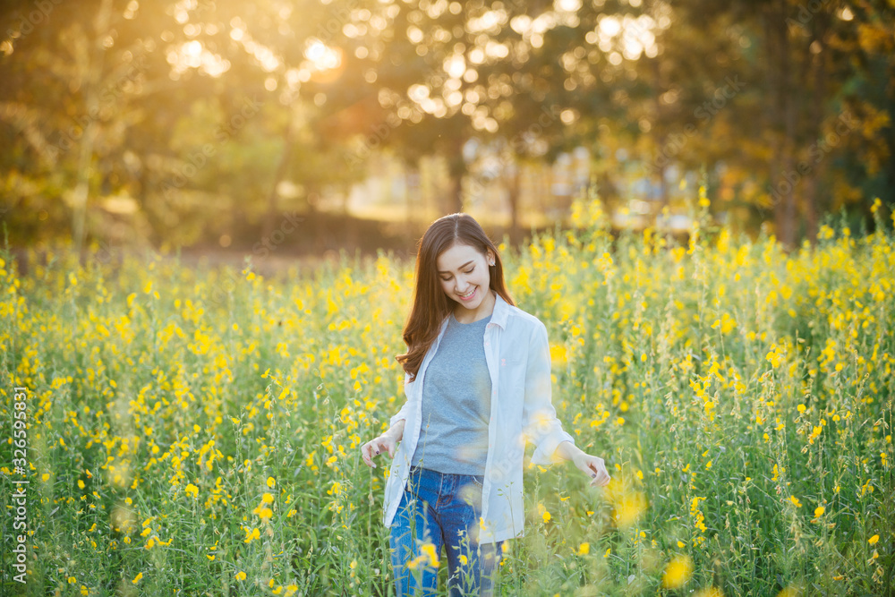 cheerful asian young woman on the field at sunset cheerful asian young woman on the field at sunset