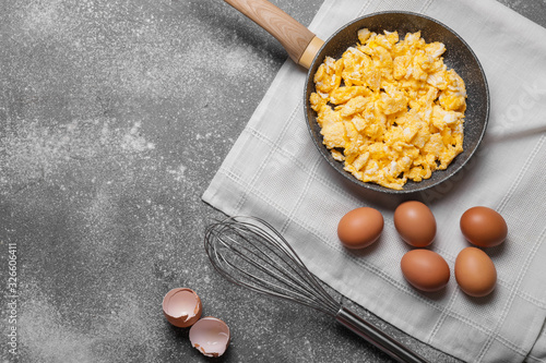 Tableau sur toile Frying pan with scrambled egg on grey background
