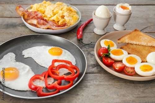 Different tasty dishes with eggs on wooden table