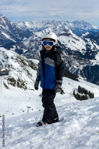 Child, skiing in winter ski resort on a sunny day, enjoying sports in nature