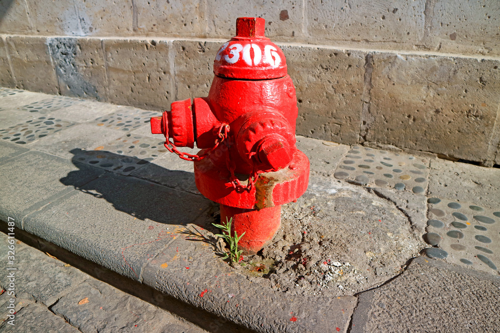 Red fire hydrant on the sidewalk of the old city of Arequipa, Peru, South America Red fire hydrant on the sidewalk of the old city of Arequipa, Peru, South America