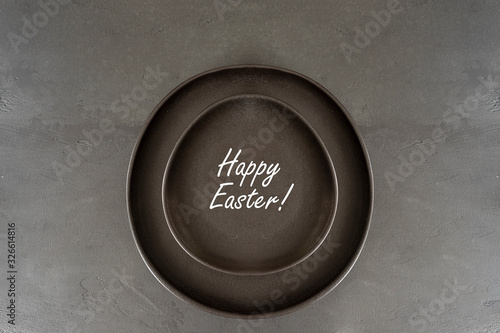 Black Egg Shaped Plate on dark large background. Minimalist style. Happy Easter concept. Copy space