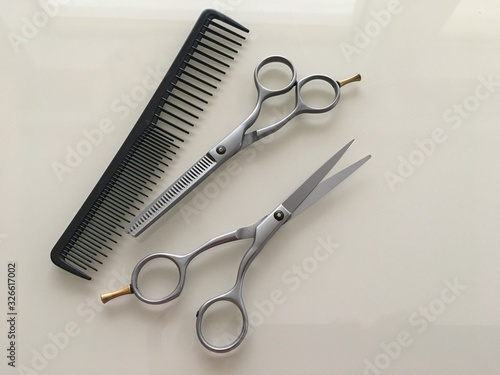 Comb and Scissors Set on a gray background for the work of a hairdresser. Photo of hairdresser tools for styling a beauty salon.