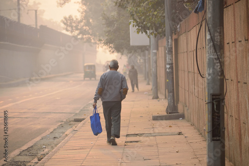 A man walking on the streets of Delhi amidst smog photo