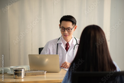 Asian Doctor and patient talking and checking  health care medicall sickness at hospital photo