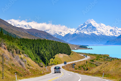 The road curves along Lake Pukaki and Mount Cook on a clear day at Peter's Lookout in the South Island of New Zealand.