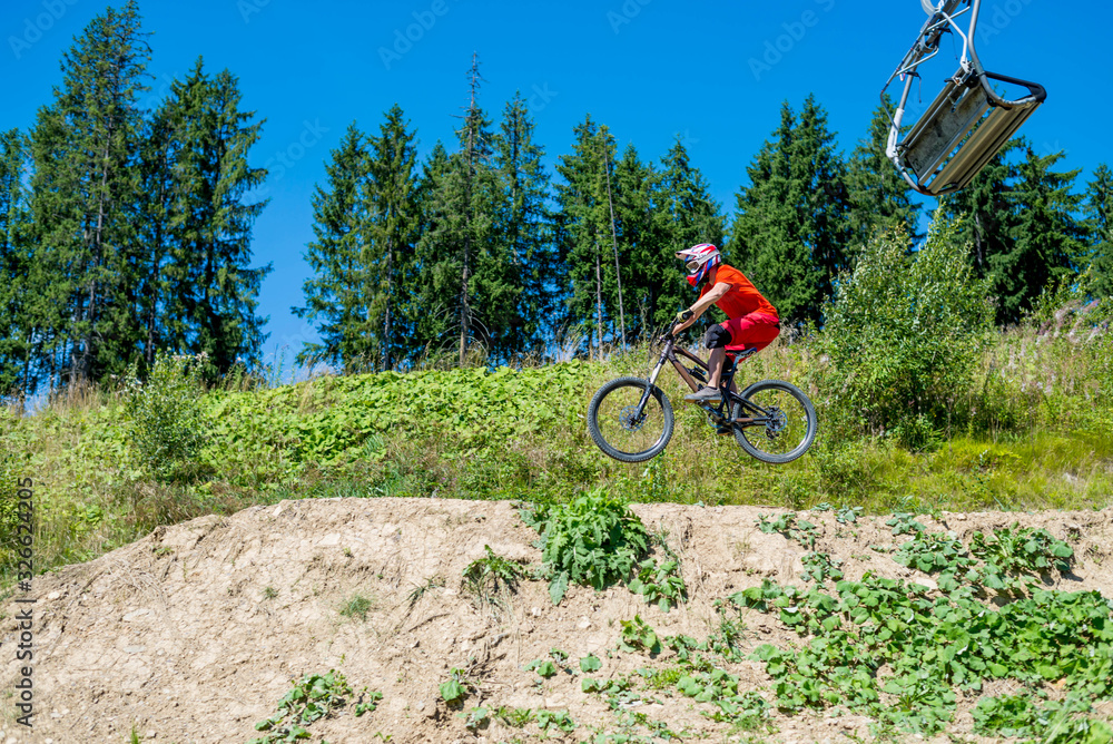 Obraz premium Professional cyclist on a mountain bike makes the jump, space.