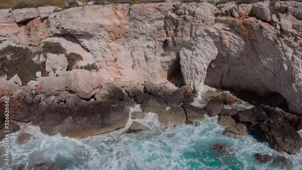 aerial drone view of beautiful waves crashing at rocky cliff with splashing and white foam, cyprus landscape Aya Napa aerial drone view of beautiful waves crashing at rocky cliff with splashing and white foam, cyprus landscape Aya Napa
