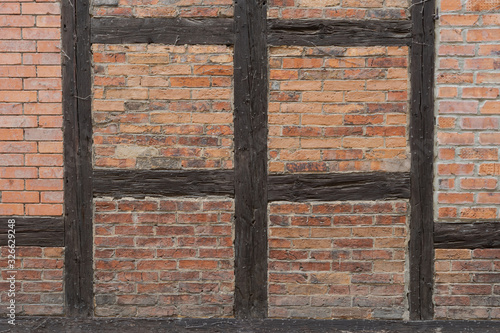 Detail of withered half timber wall with wood and bricks