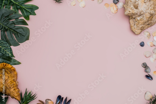 Summer composition. Tropical leaves, seashells on pastel pink background. Summer concept. Flat lay, top view, copy space.