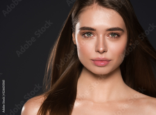 Beautiful woman natural make up long smooth healthy hair brunette cosmetic concept female beauty skin care over black background photo