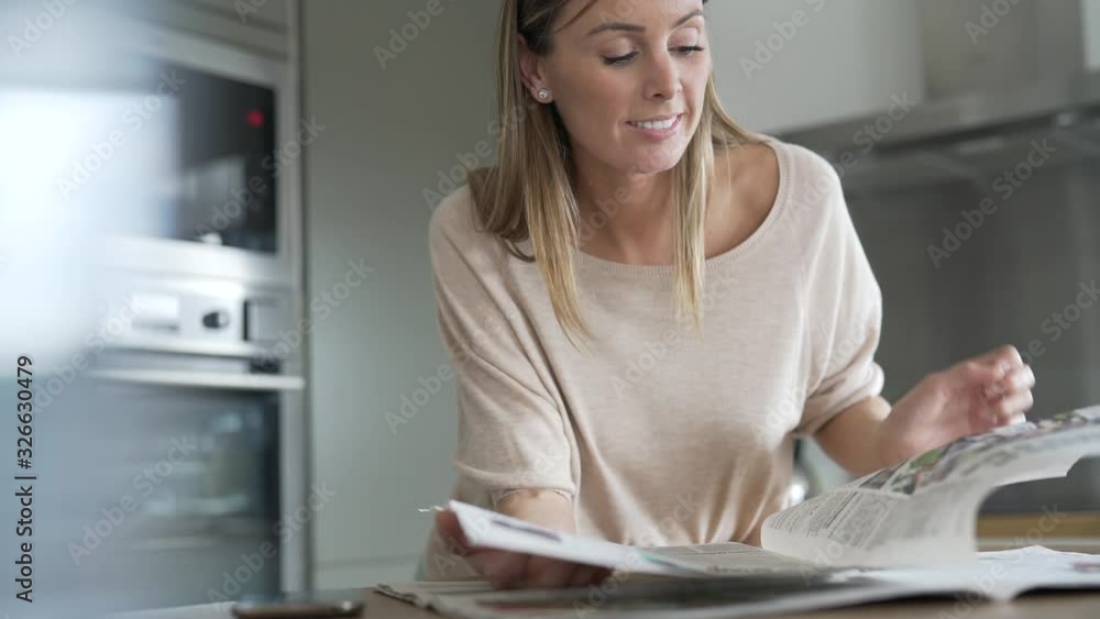 Woman at home relaxing and reading newspaper Woman at home relaxing and reading newspaper