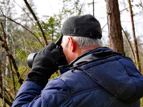 Älterer Mann fotografiert im Wald