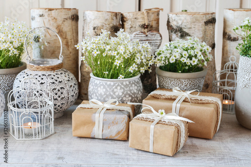 Beautifully wrapped gifts and floral decoration in the background.