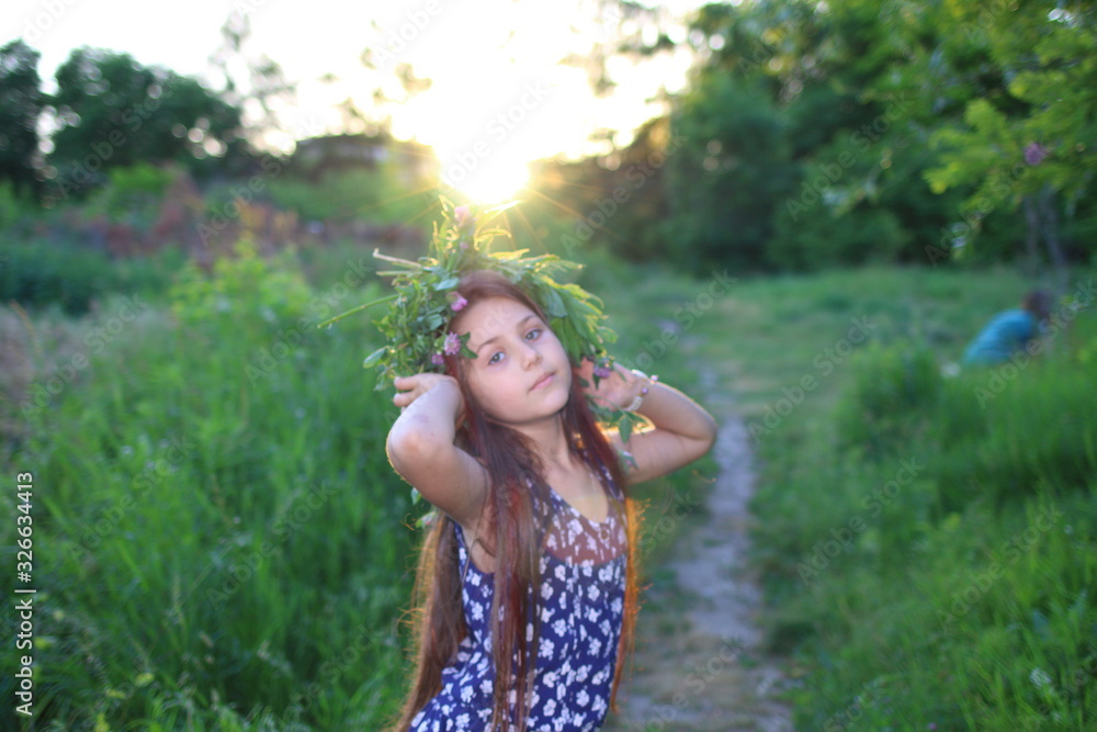 Cute Caucasian girl in a flower wreath walks at sunset in the park. The concept of summer and relaxation. Vacations and leisure for children. Nature and flowers.
Cute Caucasian girl in a flower wreath walks at sunset in the park. The concept of summer and relaxation. Vacations and leisure for children. Nature and flowers.