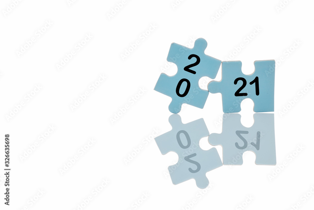 New year 2021 on blue puzzle with reflection on white background, business concept and success idea New year 2021 on blue puzzle with reflection on white background, business concept and success idea