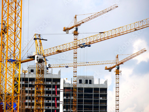 Construction site background. Four cranes near buildings. Industrial background.