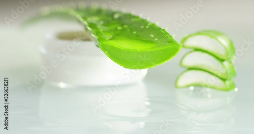 Closeup green fresh organic aloe vera leaf with aloevera slices in wooden spoon isolated on white background. Top view. Flat lay.