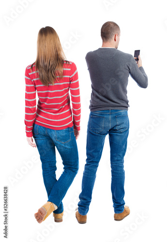 Back view of couple in sweater with mobile phone.