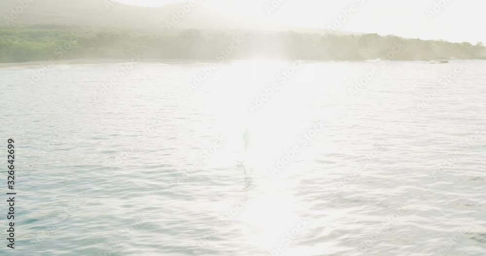 Aerial view of a man on an electric hydrofoil personal water craft surfboard riding in the ocean at sunrise, the future of water vehicles and transport Aerial view of a man on an electric hydrofoil personal water craft surfboard riding in the ocean at sunrise, the future of water vehicles and transport