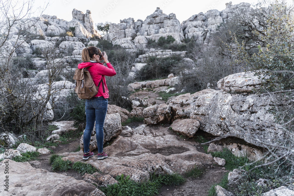Young woman explorer photographing in the mountain. Concept of adventure, excursion and trips. Young woman explorer photographing in the mountain. Concept of adventure, excursion and trips.