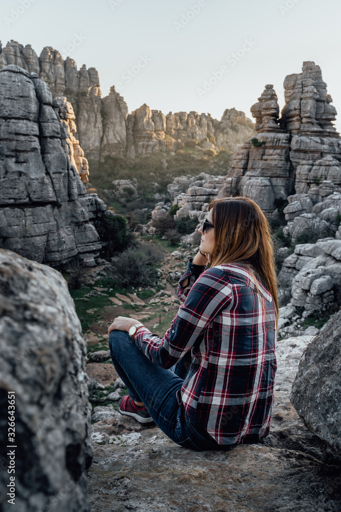 Fototapeta premium Young woman scout sitting, looking at the mountains. Concept of adventure, excursion and trips.