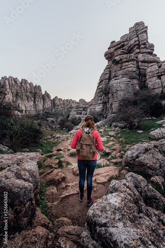 Young woman explorer with her backpack walking on the mountain. Concept of adventure, excursion and trips.