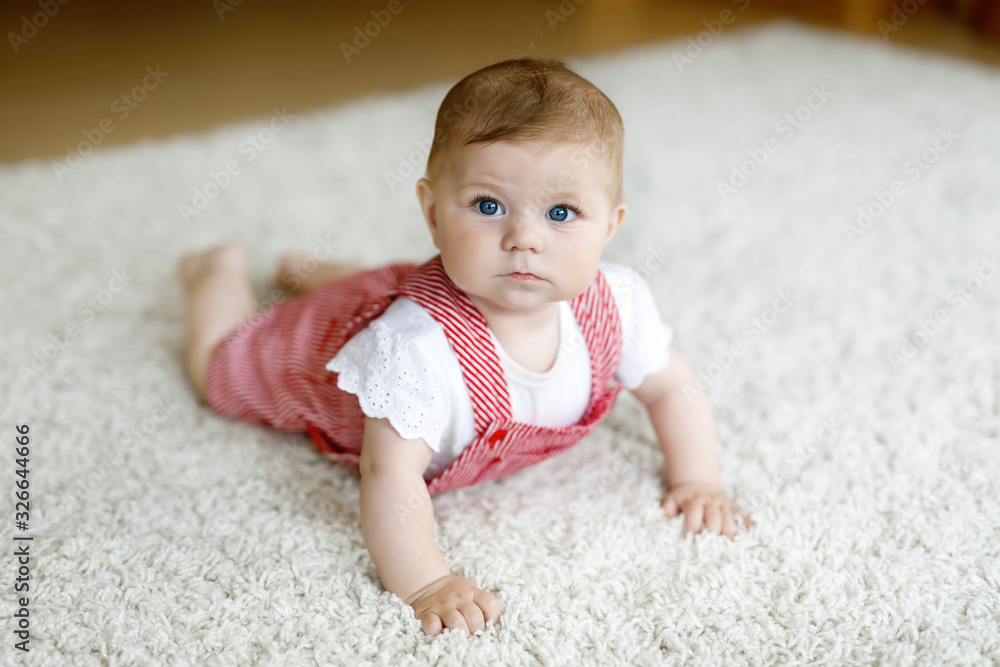 Lovely baby girl in white sunny bedroom. Newborn child learning crawling. Nursery for children. Textile and bedding for kids. Happy child looking in a camera Lovely baby girl in white sunny bedroom. Newborn child learning crawling. Nursery for children. Textile and bedding for kids. Happy child looking in a camera