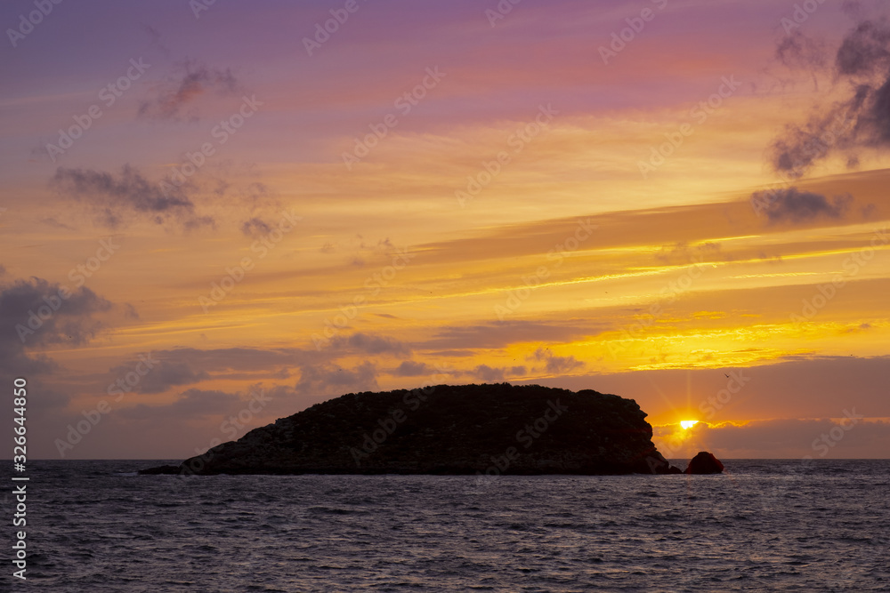 Sunrise with red sky on the beach of Es Canar, Ibiza Island, Spain