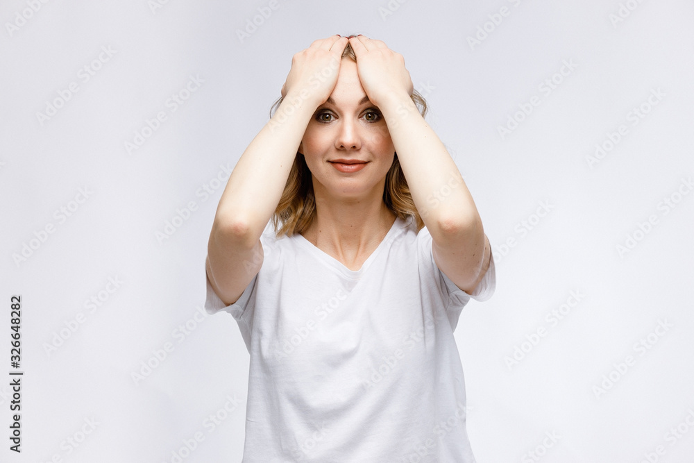 Facial gymnastics. A young girl shows exercises for facial muscles in close-up on a white background.