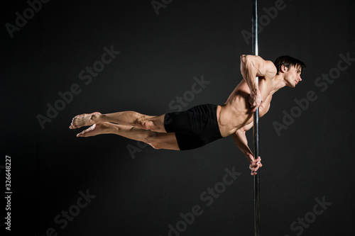 Portrait of male model performing a pole dance
