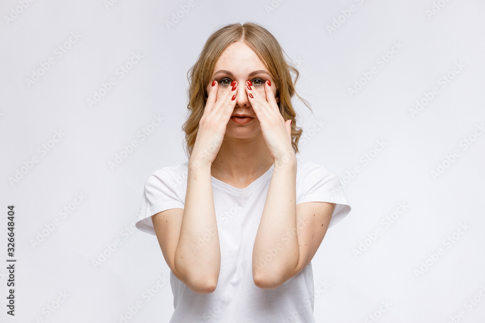Facial gymnastics. A young girl shows exercises for facial muscles in close-up on a white background. Facial gymnastics. A young girl shows exercises for facial muscles in close-up on a white background.